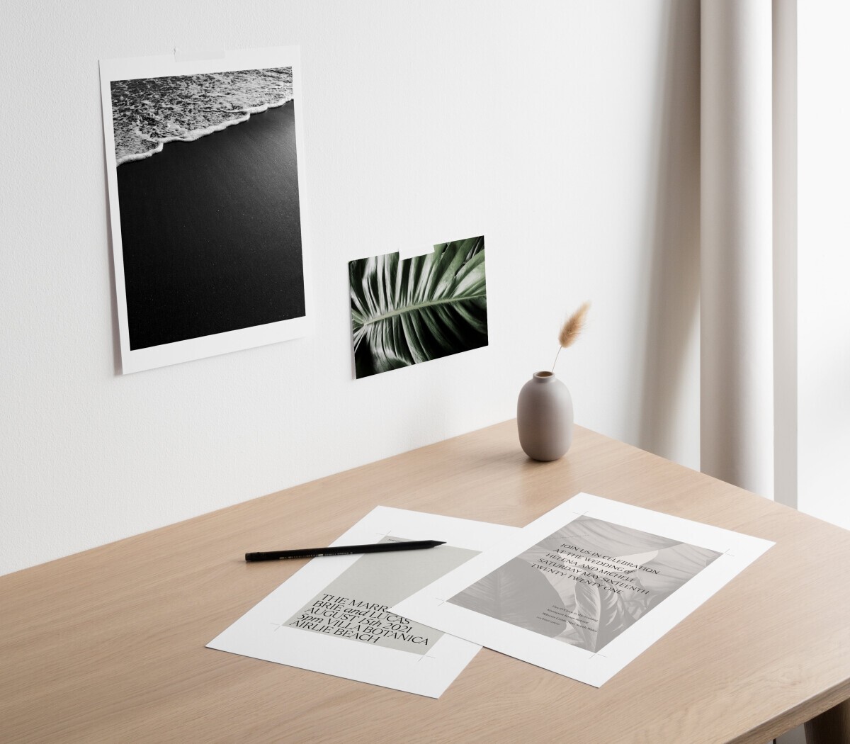 A desk with mockups of a tropical wedding invitation on top