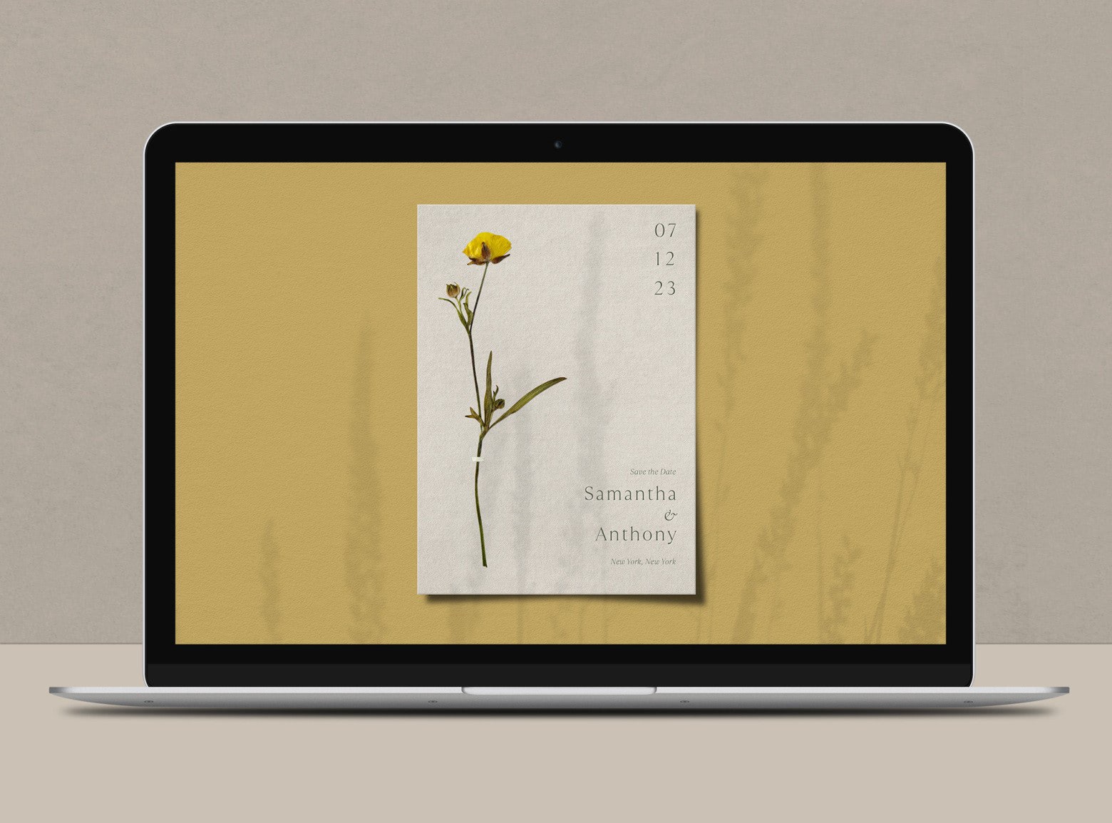 An iPad screen displaying a white, green and yellow virtual Save the Date with a long-stemmed yellow flower on it